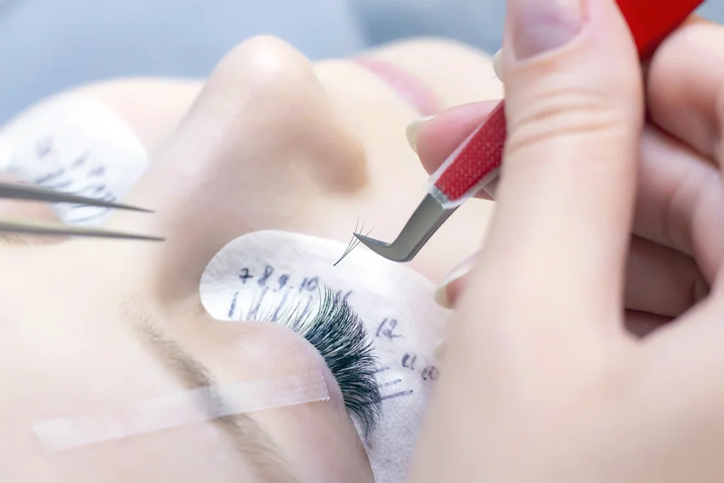 photo d'une personne en train de poser les extension de cil pour sa formation